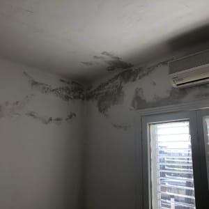 קיר עם סימני רטיבות ותיקוני צבע