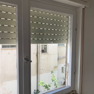 חלון זכוכית עם תריסים חצי סגורים