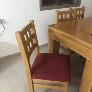 כיסא עץ עם ריפוד אדום ליד שולחן עץ