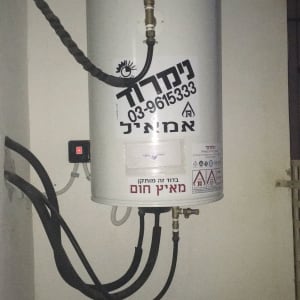 דוד שמש עם צינורות וחיבורים מותקנים על קיר