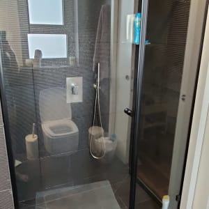 דלת זכוכית למקלחת עם ידית שחורה