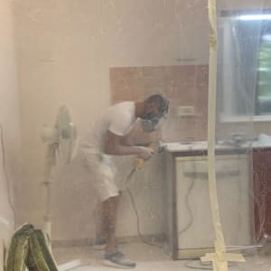 אדם עובד על שיש במטבח עם כלי עבודה