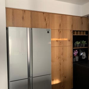 מקרר כסוף וארונות עץ במטבח מודרני