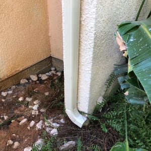 מרזב לבן מחובר לקיר חיצוני של מבנה