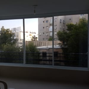 חלון הזזה מרווח מאלומיניום לבן בסגירת מרפסת