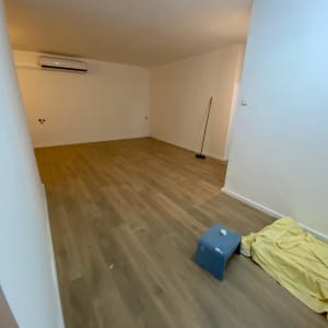 רצפת פרקט עם מטאטא וכיסא פלסטיק