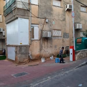 שער חשמלי לבן עם עמוד אדום ולבן בצד הדרך