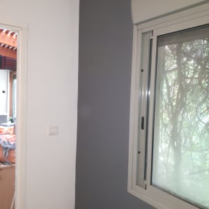 קיר צבוע בשני צבעים, אפור ולבן, ליד חלון