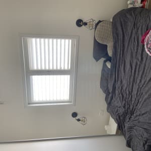 חדר שינה עם מיטה, חלון ומזגן על הקיר