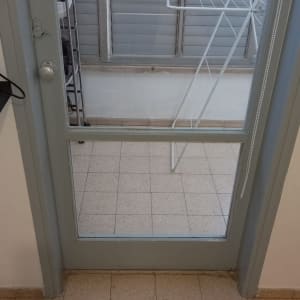 דלת זכוכית עם מסגרת מתכת אפורה