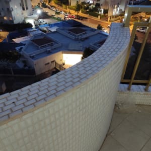 מעקה מרוצף באריחים קטנים על מרפסת