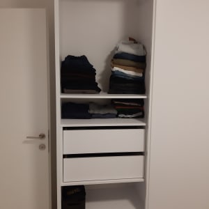 ארון בגדים עם מדפים, מגירות ובגדים מקופלים