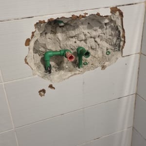 צנרת ירוקה בקיר פתוח עם חיבורים