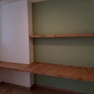 מדפי עץ מותקנים על קיר ירוק