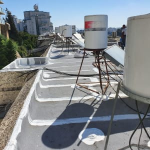 איטום גג עם חומר לבן סביב דודי שמש