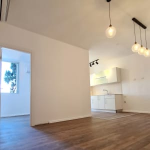 מטבח חדש עם ארונות לבנים ותאורה תלויה