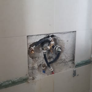 צנרת חשופה בקיר עם חיבורים וצינורות