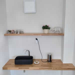 כיור שחור וברז על משטח עץ במטבח