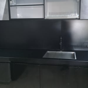 ארונות מטבח שחורים עם כיור וברז