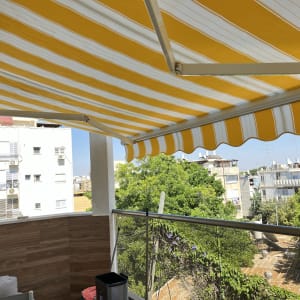Yellow and white striped awning on a balcony