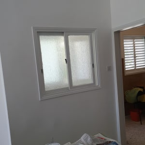 פחית צבע ומברשת על עיתונים בחדר צבוע