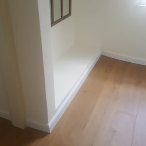 רצפת פרקט עץ בהירה ליד קיר לבן