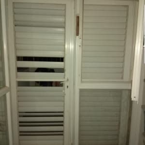 תריסים לבנים סגורים על חלון זכוכית