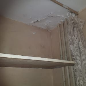 תקרה מתקלפת עם סימני רטיבות ופגמים בצבע