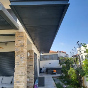 גינה עם שביל אבן, צמחים וגדר עץ.