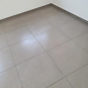 רצפה נקייה עם אריחים אפורים בחדר ריק