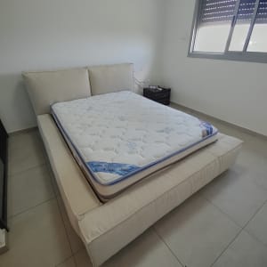 מזרן על מיטה מרופדת בחדר שינה