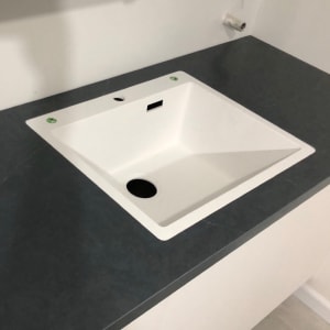 כיור משובץ בשיש כהה עם משטח חלק