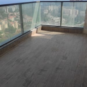 מרפסת עם רצפת עץ וניקוז, ללא כלי ניקוי נראים