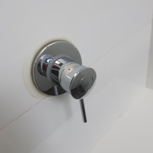 ברז כרום על קיר לבן עם כתמי לכלוך