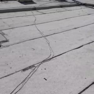 גג עם יריעות איטום ואדם עומד ליד מזגן