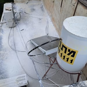 מיכל מים על גג עם צינורות ואיטום