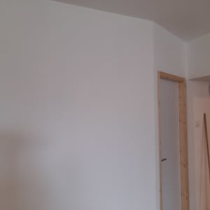 קיר גבס לבן עם דלת עץ