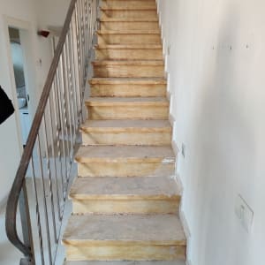 מדרגות עץ מלוכלכות עם מעקה מתכת