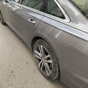 מכונית אפורה עם גלגלים וסימני לכלוך על הגוף