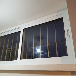 חלון אלומיניום עם מסגרת לבנה וסורגים