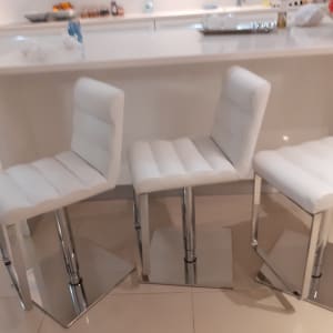 כיסאות בר מרופדים בלבן עם בסיס מתכת מבריק
