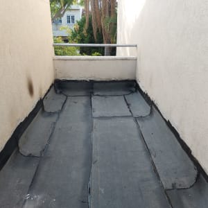 גג אטום ביריעות ביטומניות שחורות עם קירות בטון