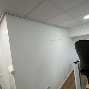 קיר צבוע בלבן עם רולר צביעה על הקיר