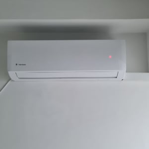 מזגן מותקן על קיר עם נורית חיווי אדומה