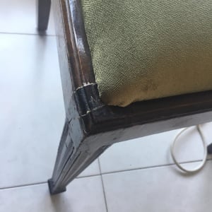 כרית ירוקה על כיסא עץ עם רגליים כהות