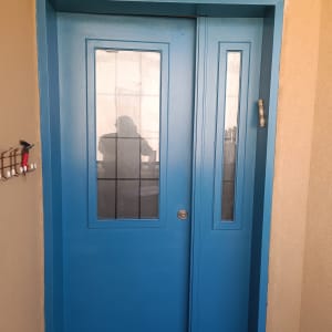 דלת כחולה עם חלונות זכוכית קטנים