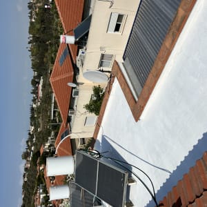 גג אטום בצבע לבן עם קולטי שמש