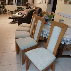 כיסאות מרופדים ליד שולחן בסלון מואר