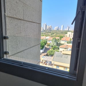 חלון זכוכית פתוח עם נוף עירוני ברקע