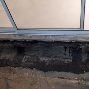 אזור אטום עם חומר שחור ליד דלת זכוכית